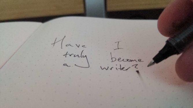 A dotted page; a pen has been lifted from it. In the middle, the words, "Have I truly become a writer?" have been written.