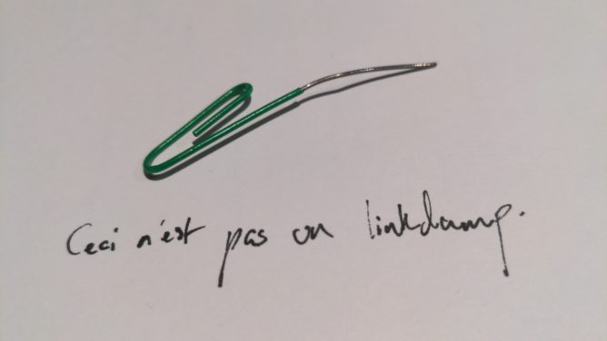 Green paperclip bent to look like a pipe. Underneath it is written, "ceci n'est pas un linkdump" ("this is not a linkdump")